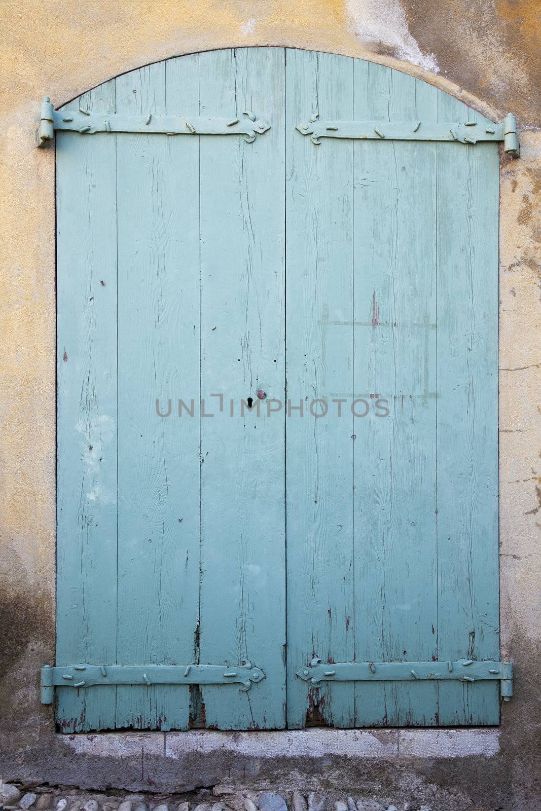 Old painted wooden door on weathered stucco building