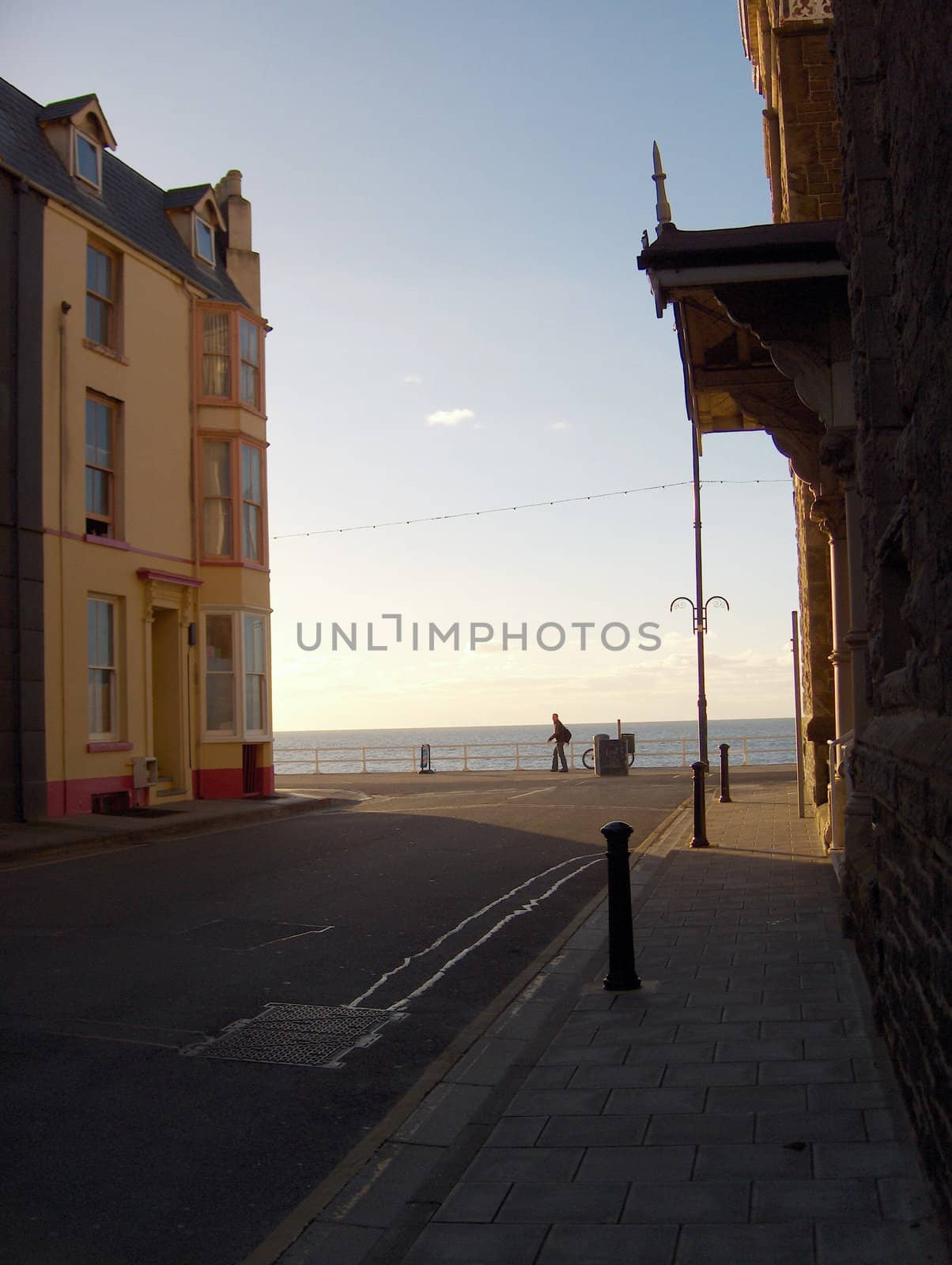 A man takes in the view of the Atlantic Ocean on an otherwise deserted street in Aberystwyth, Wales.