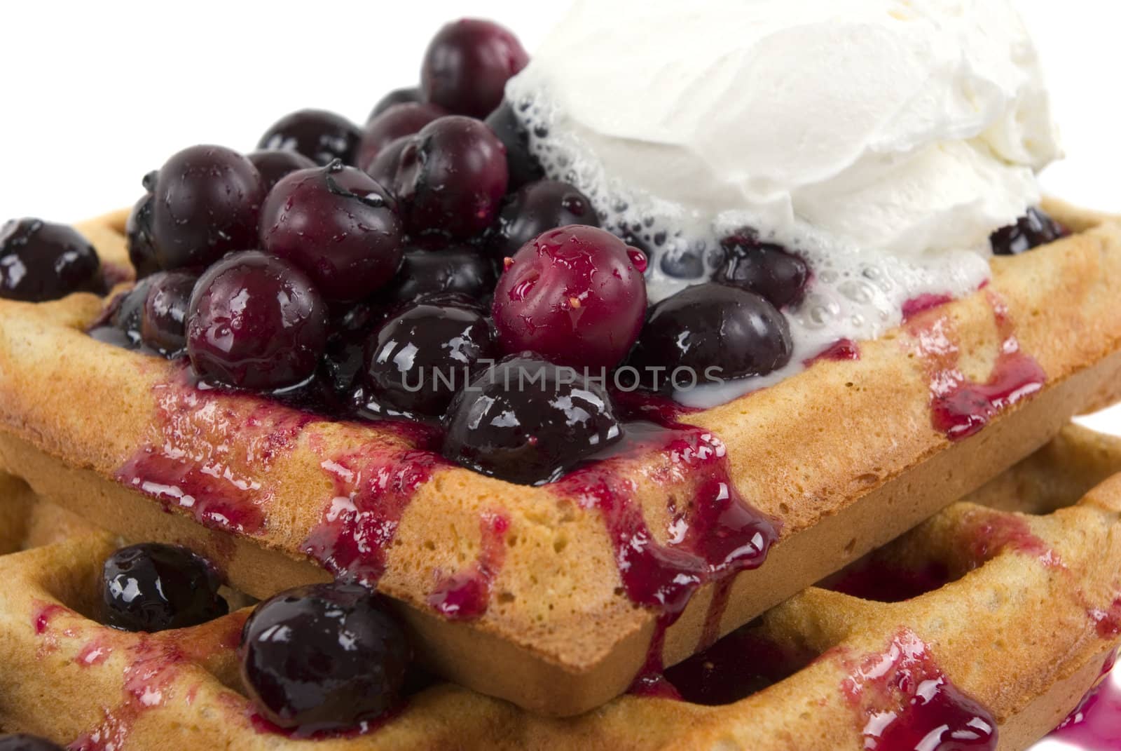 Organic hot wheat waffle with organic fresh blueberries, honey and cream