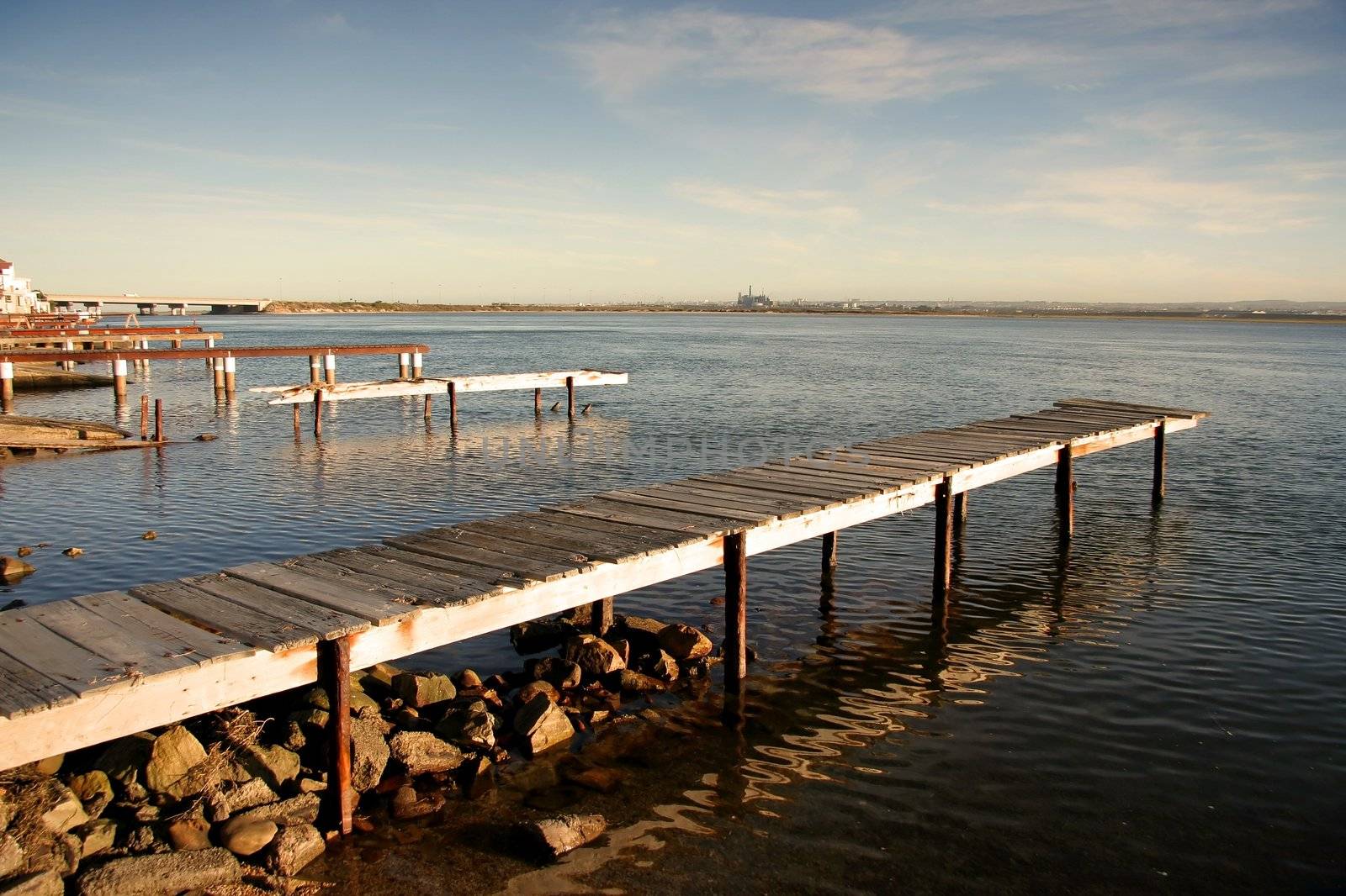 Old dilapidated jetties on a river estuary with warm afternon light