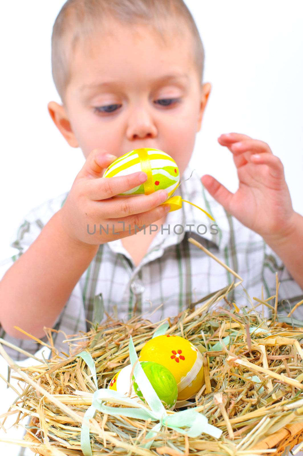 Little boy playing with easter eggs in basket. Focus on the eggs.