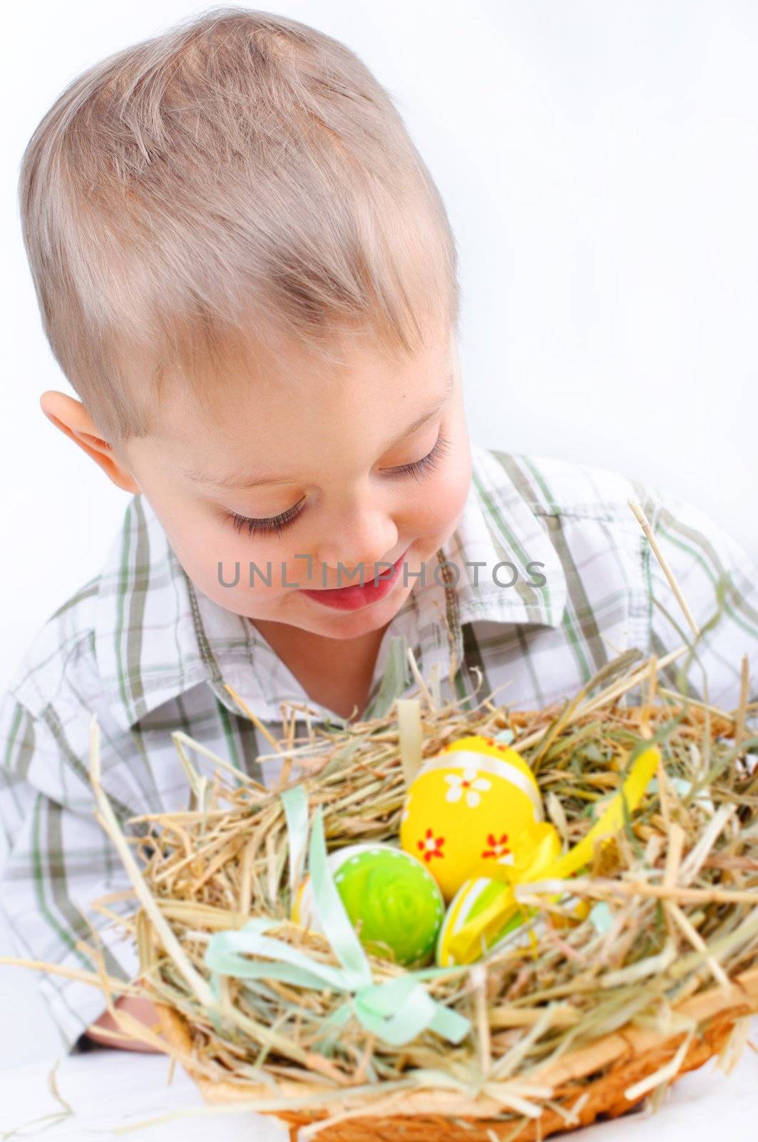 Little boy playing with easter eggs in basket