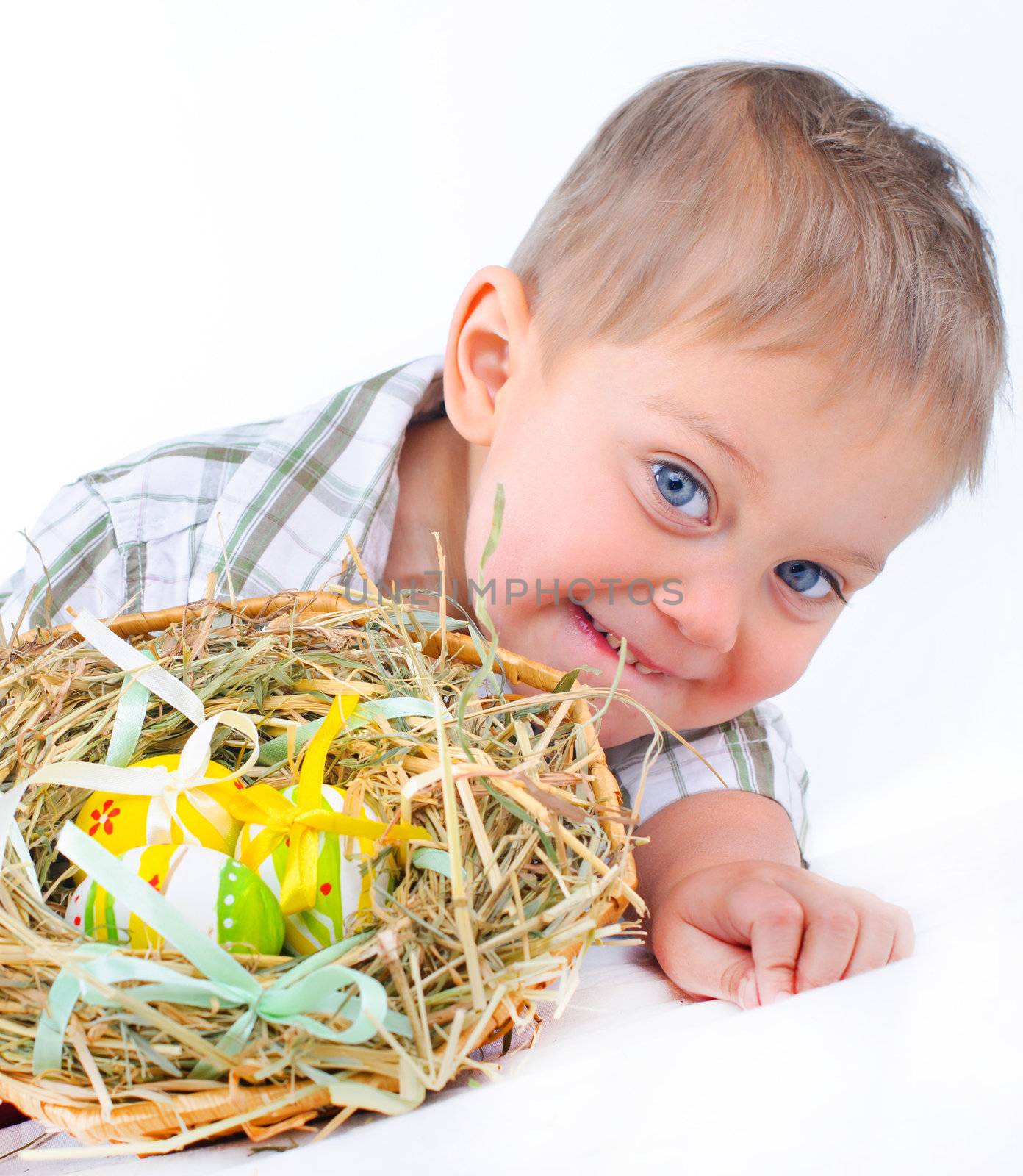 Little boy playing with easter eggs in basket