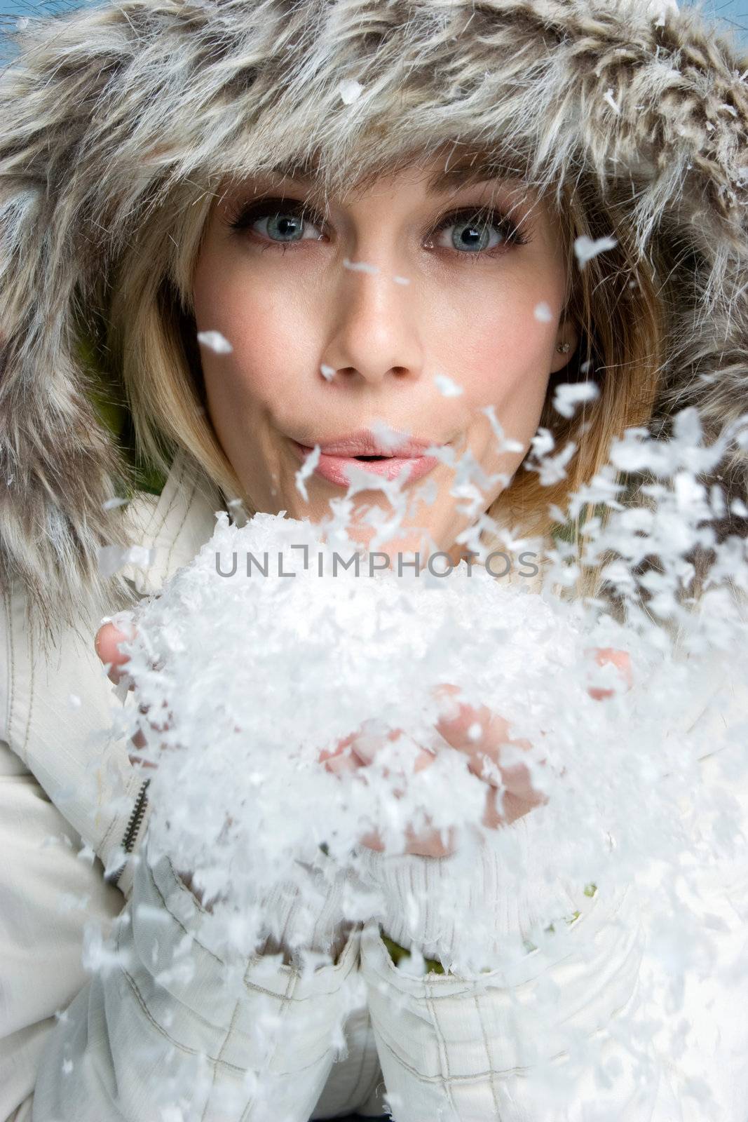 Pretty winter woman blowing snow