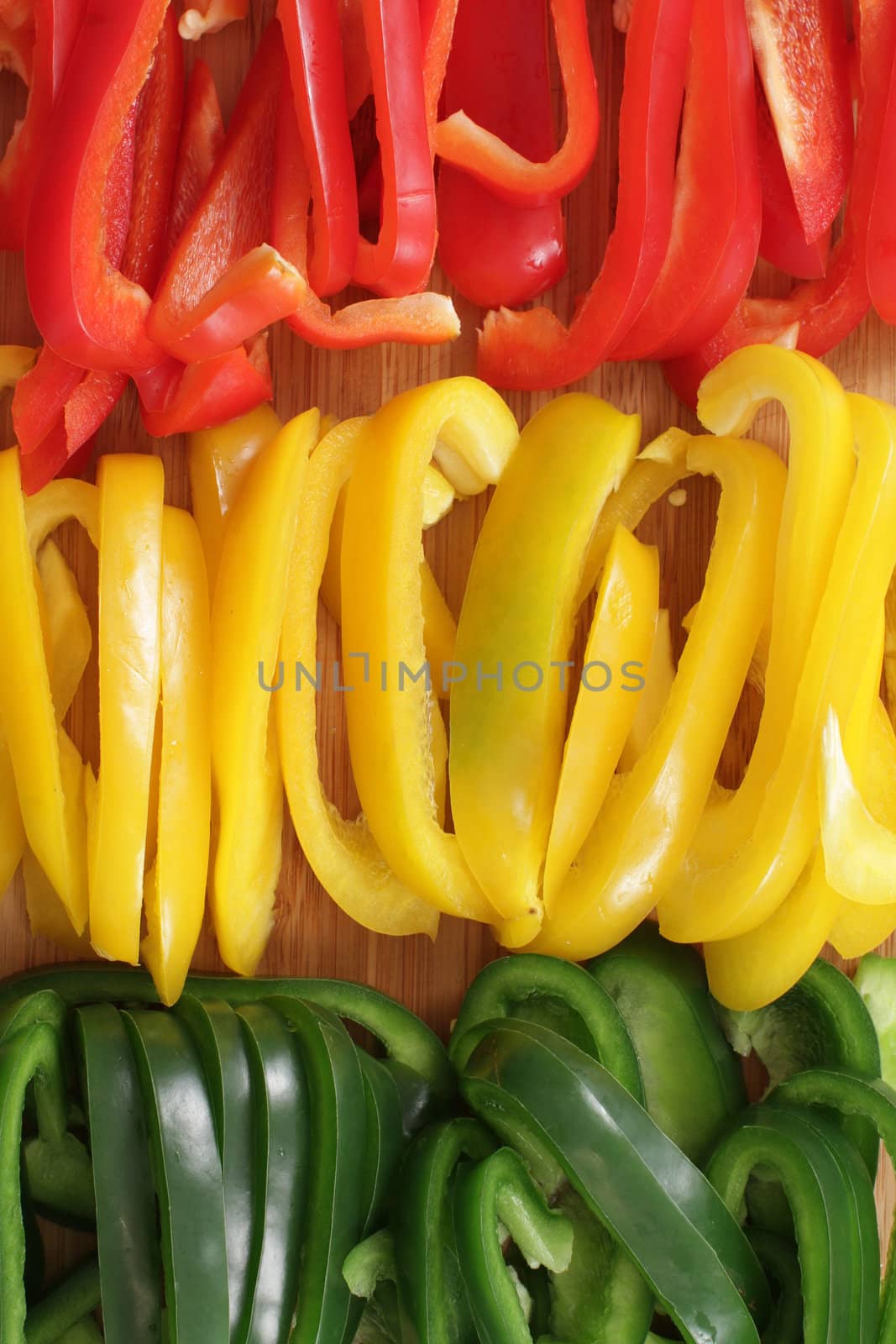 many pepper slices on a wooden background
