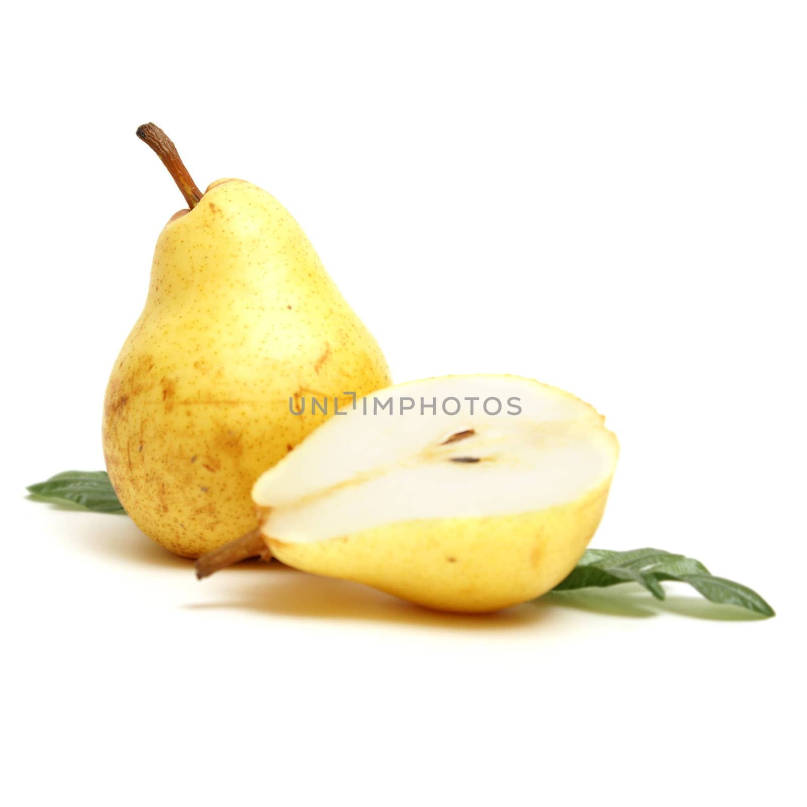 A couple of isolated pears with one that is cut in half.