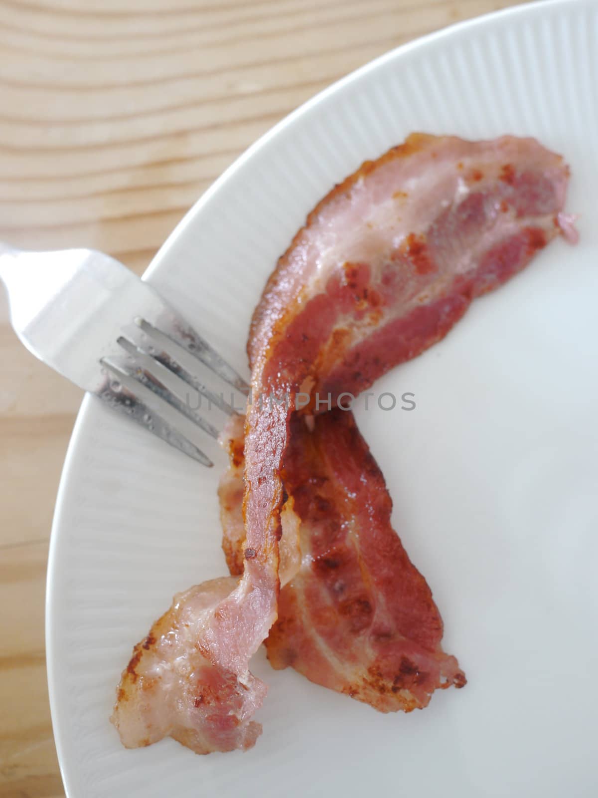 one piece of bacon on a white platter