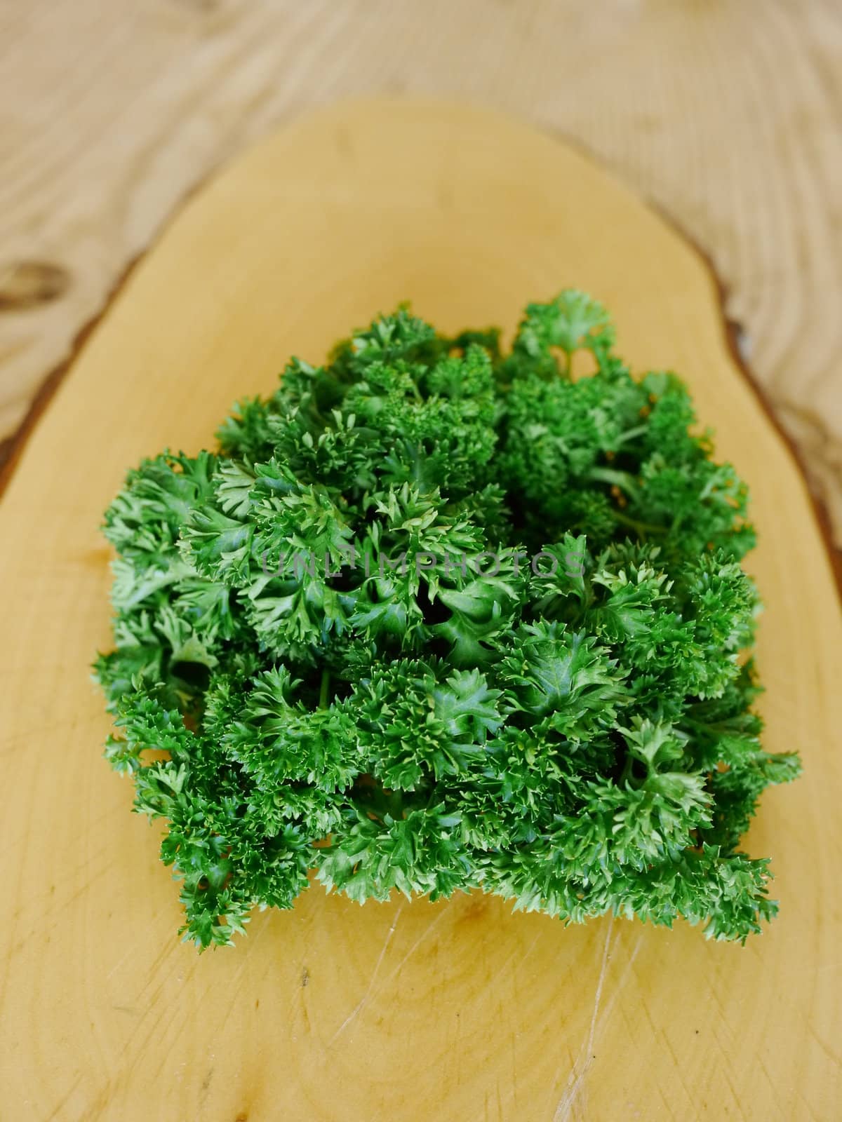 fresh bright green parsley closeup on bamboo cutting board, white background