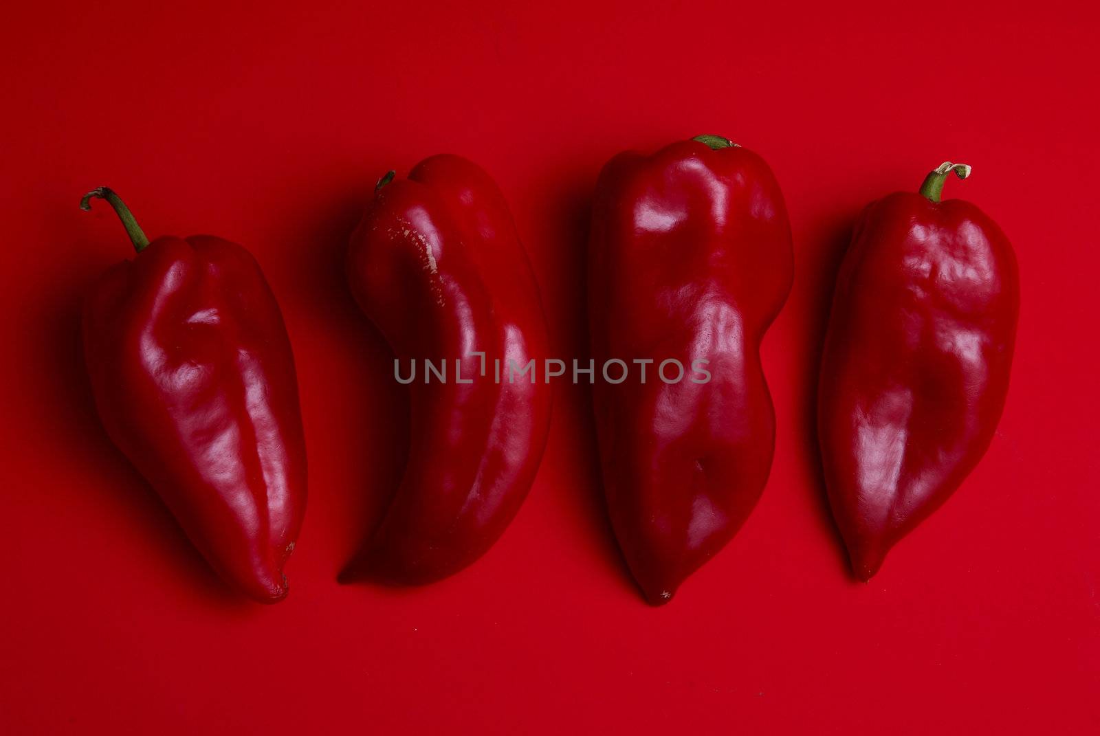 Red Peppers on red background, group of vegetables