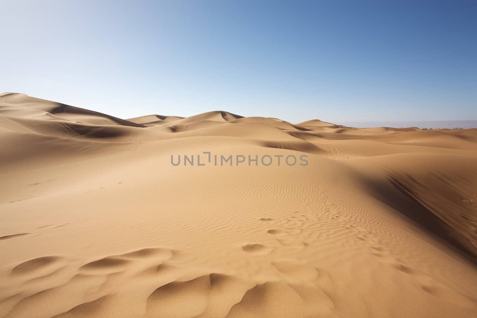 Sahara desert close to Merzouga in Morocco with blue sky and clouds