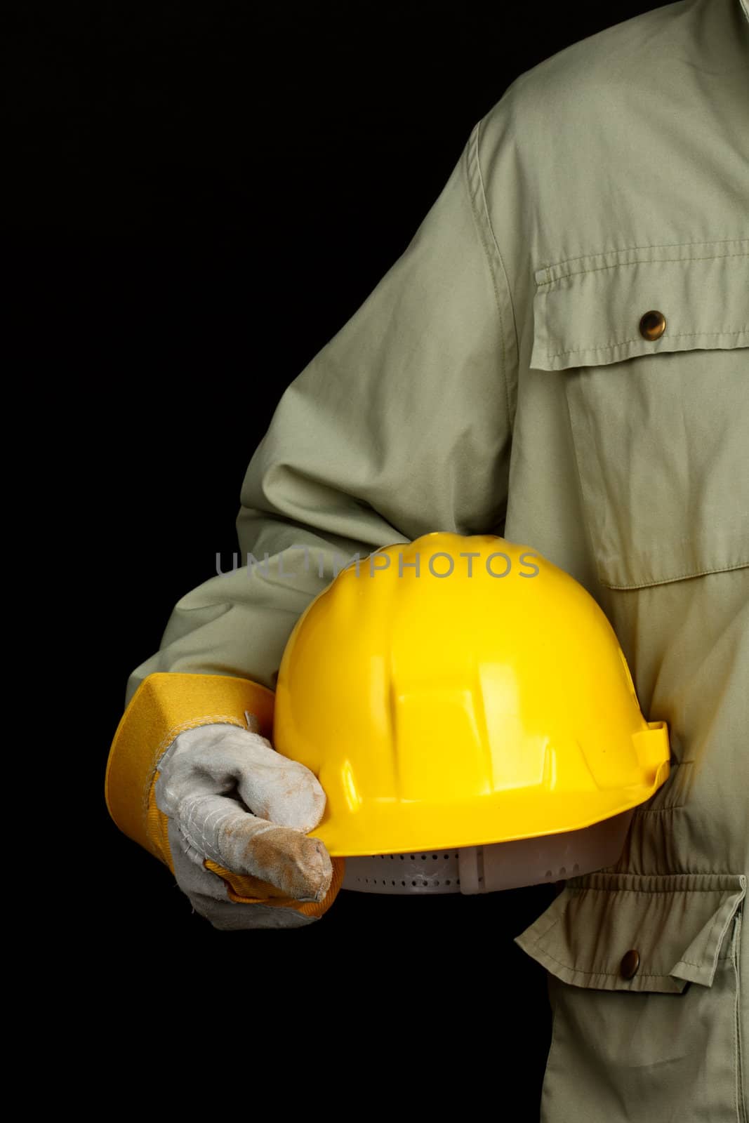 man holding yellow helmet over black background 