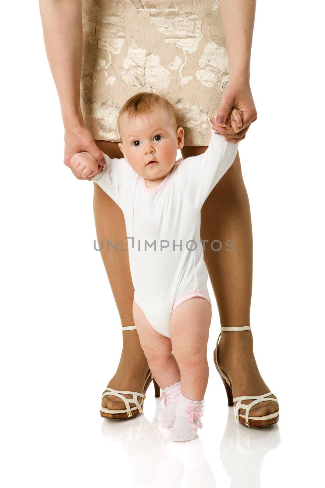 Mother holding daughter's hands first steps isolated on white