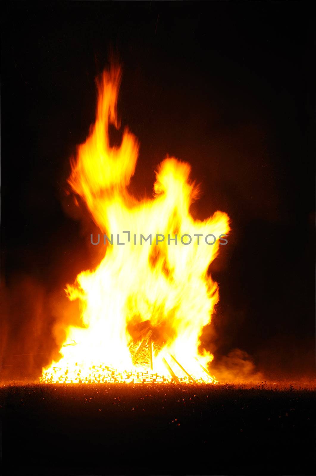 A bonfire burning against a dark background