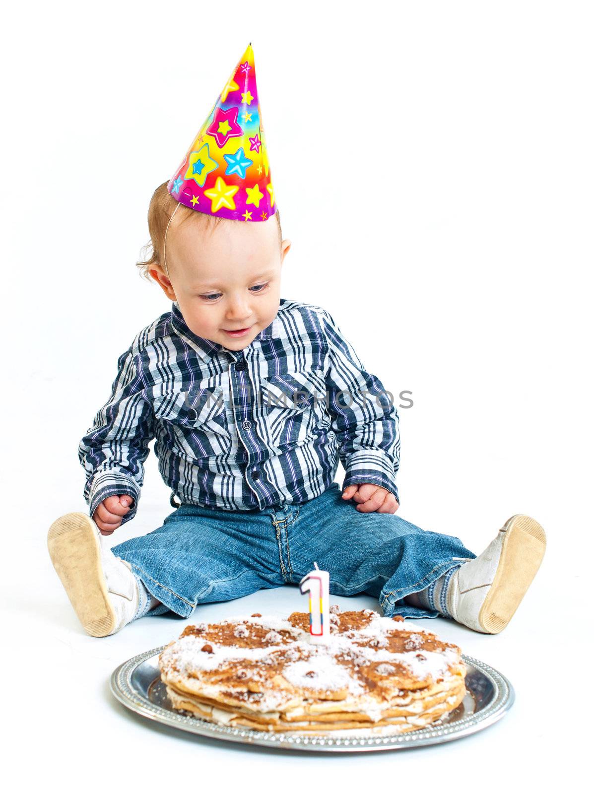 First birthday. Cute little boy in a cap with a birthday cake and a candle