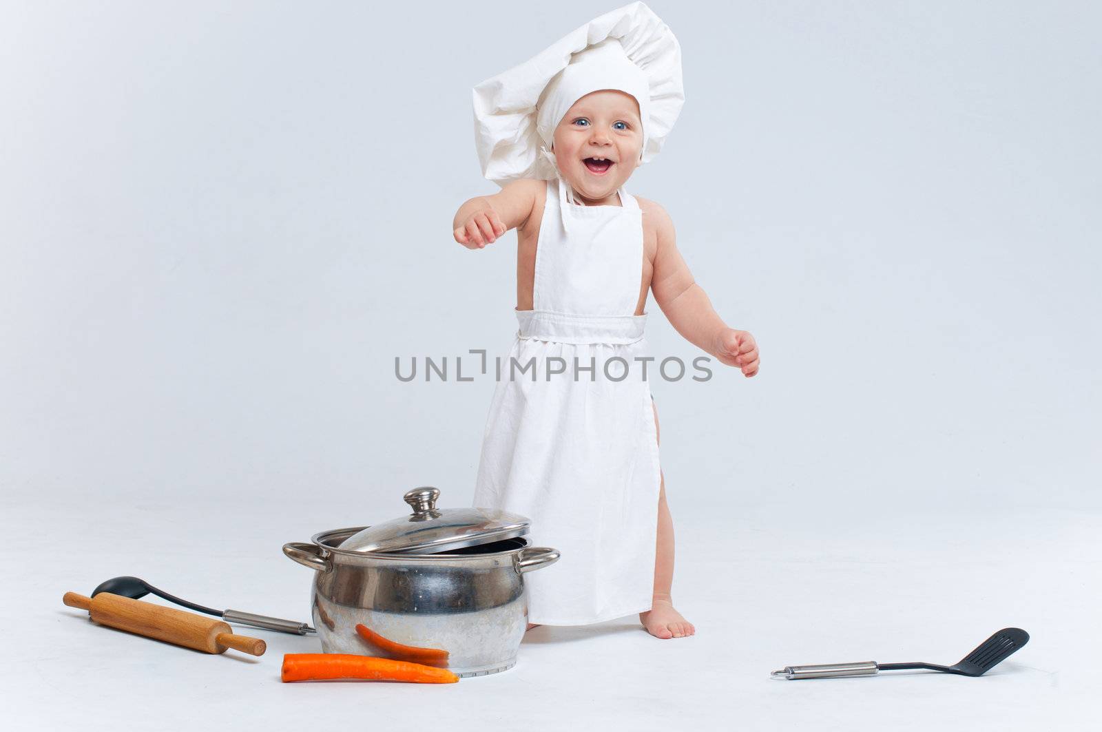 Little cook. Cute little boy in a suit of Food Boy with kitchen accessories. In the studio