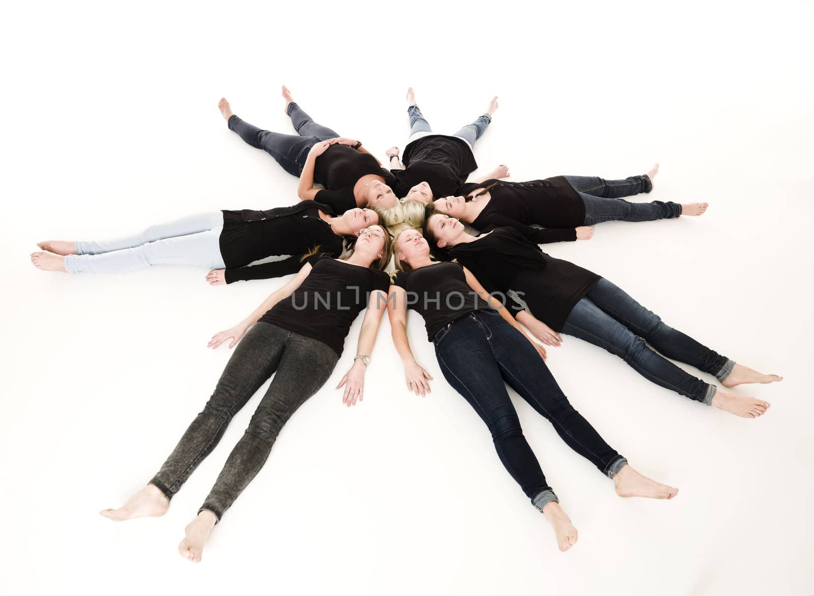 Group of Young Women lieing in a circle on white background
