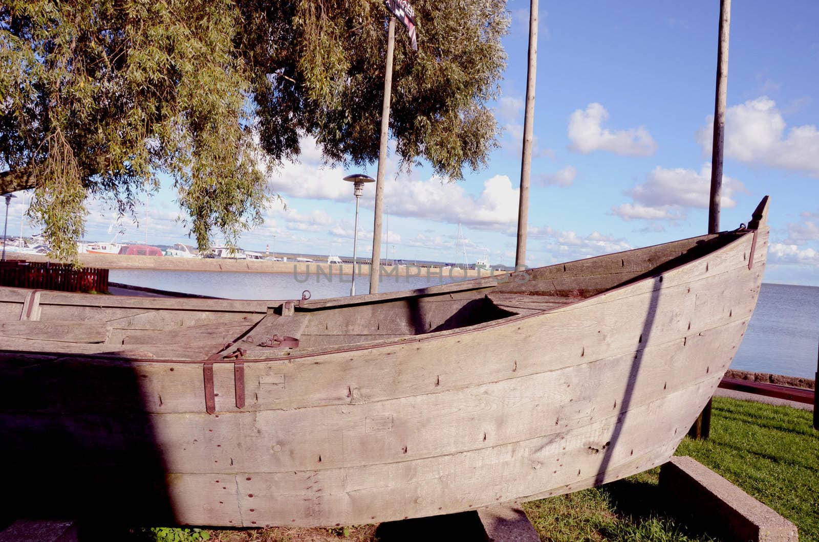 Antique wooden boat in exhibition on the lake shore.