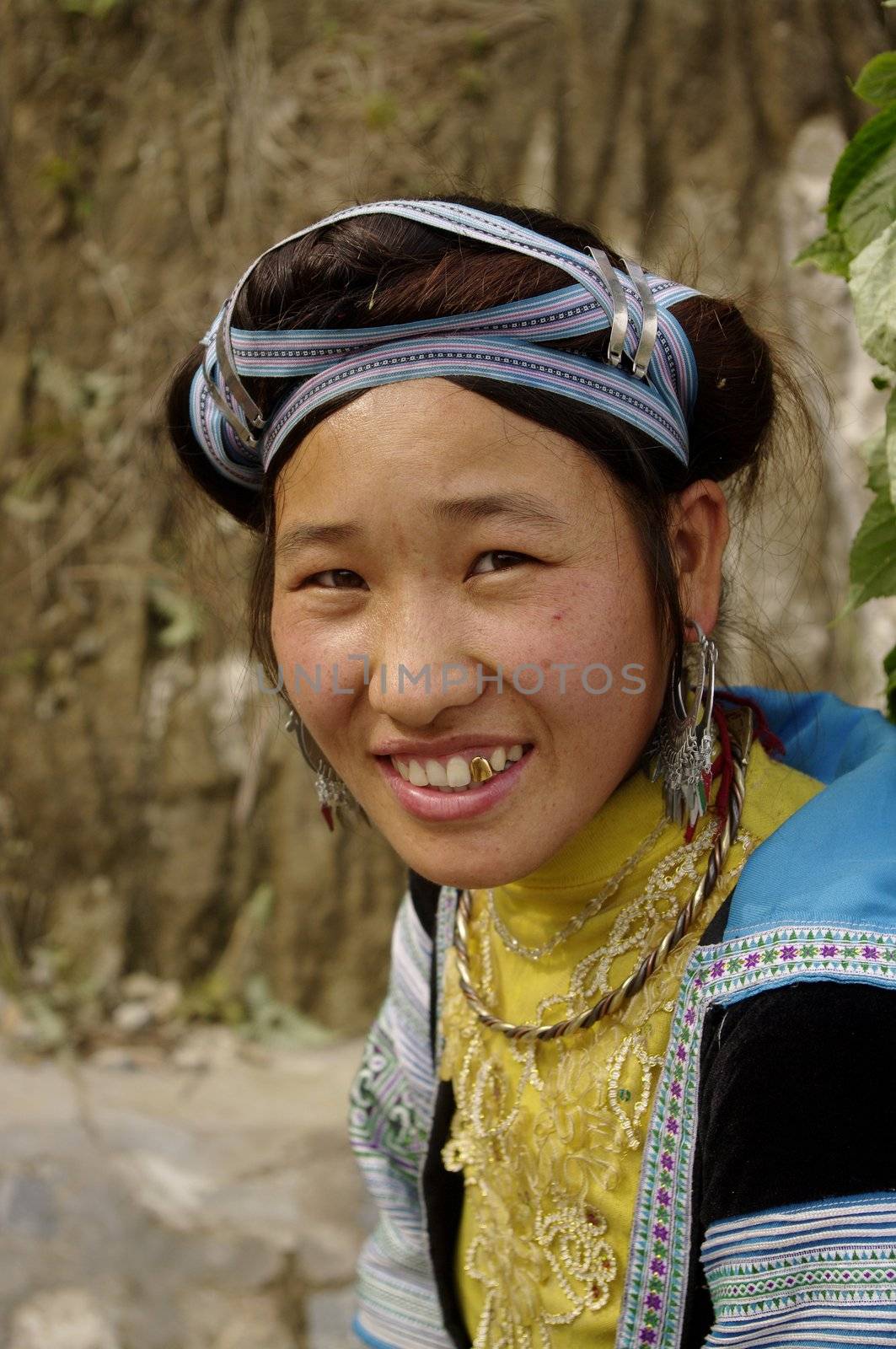 A Hmong woman blue. Her hairstyle is very neat. This ethnic group is not wearing a cap, but women have this hairstyle typical of Hmong blue with blue tape wrapped around the hair of flattened bun held by clamps silver.