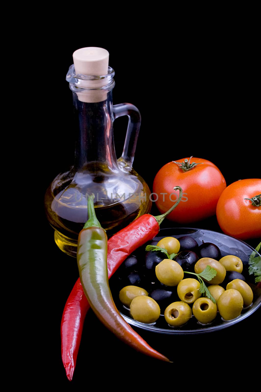Olive oil, tomatoes, pepper and greens isolated on black