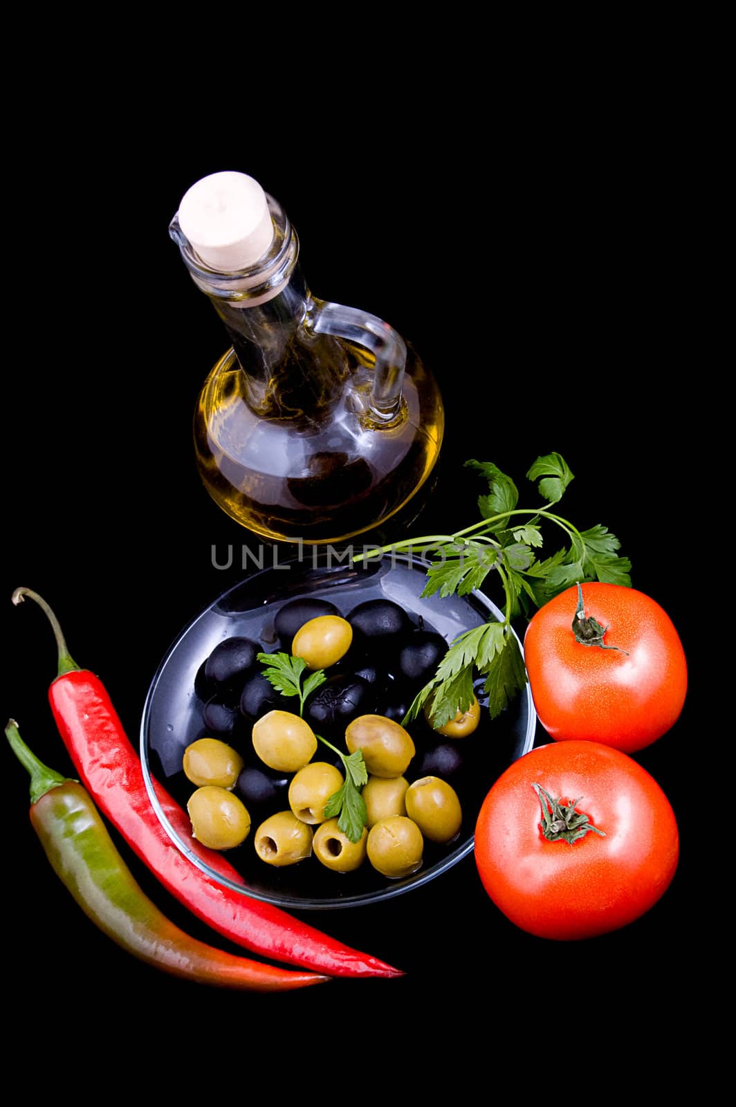 Olive oil, tomatoes, pepper and greens isolated on black