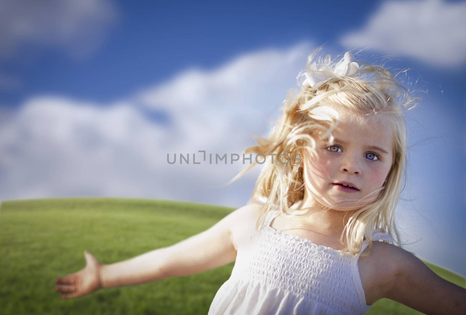 Adorable Blue Eyed Girl Playing Outside in the Grass.