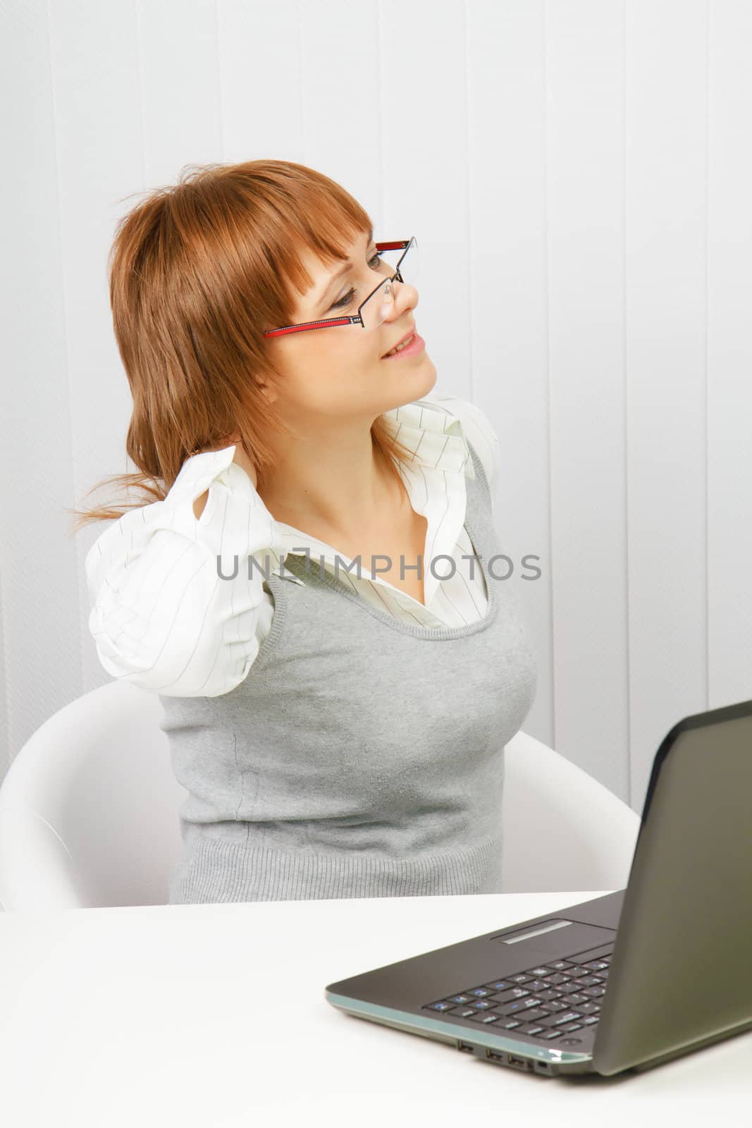 tired girl with a laptop at work doing gymnastics

