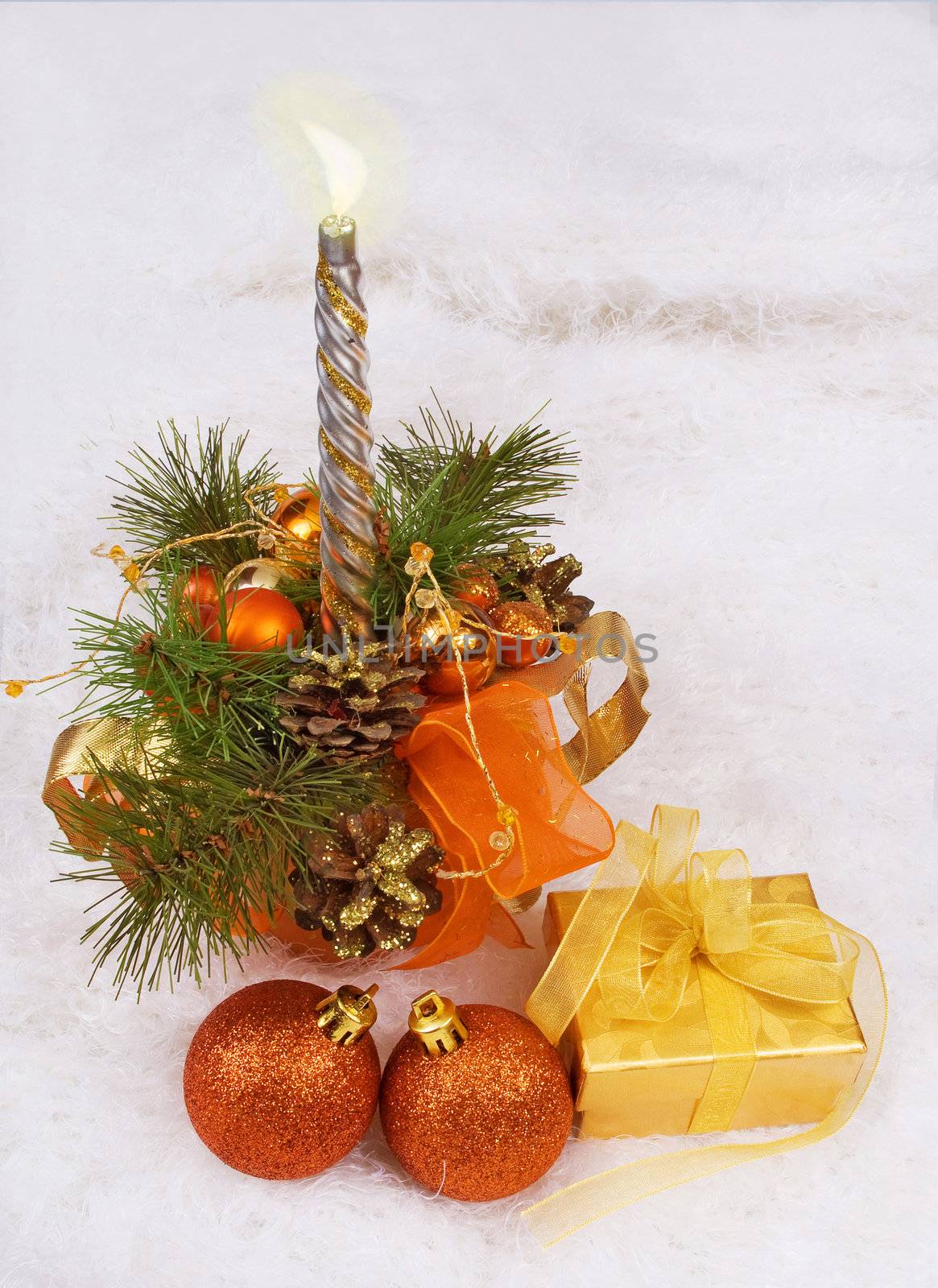 Christmas silver candles and golden box and spheres on white fur
