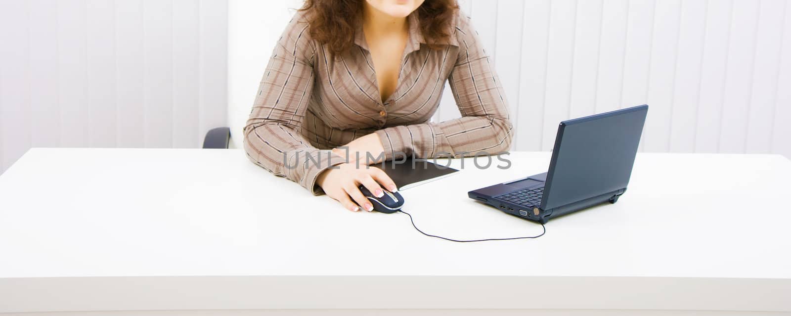 The young brunette at office with the laptop