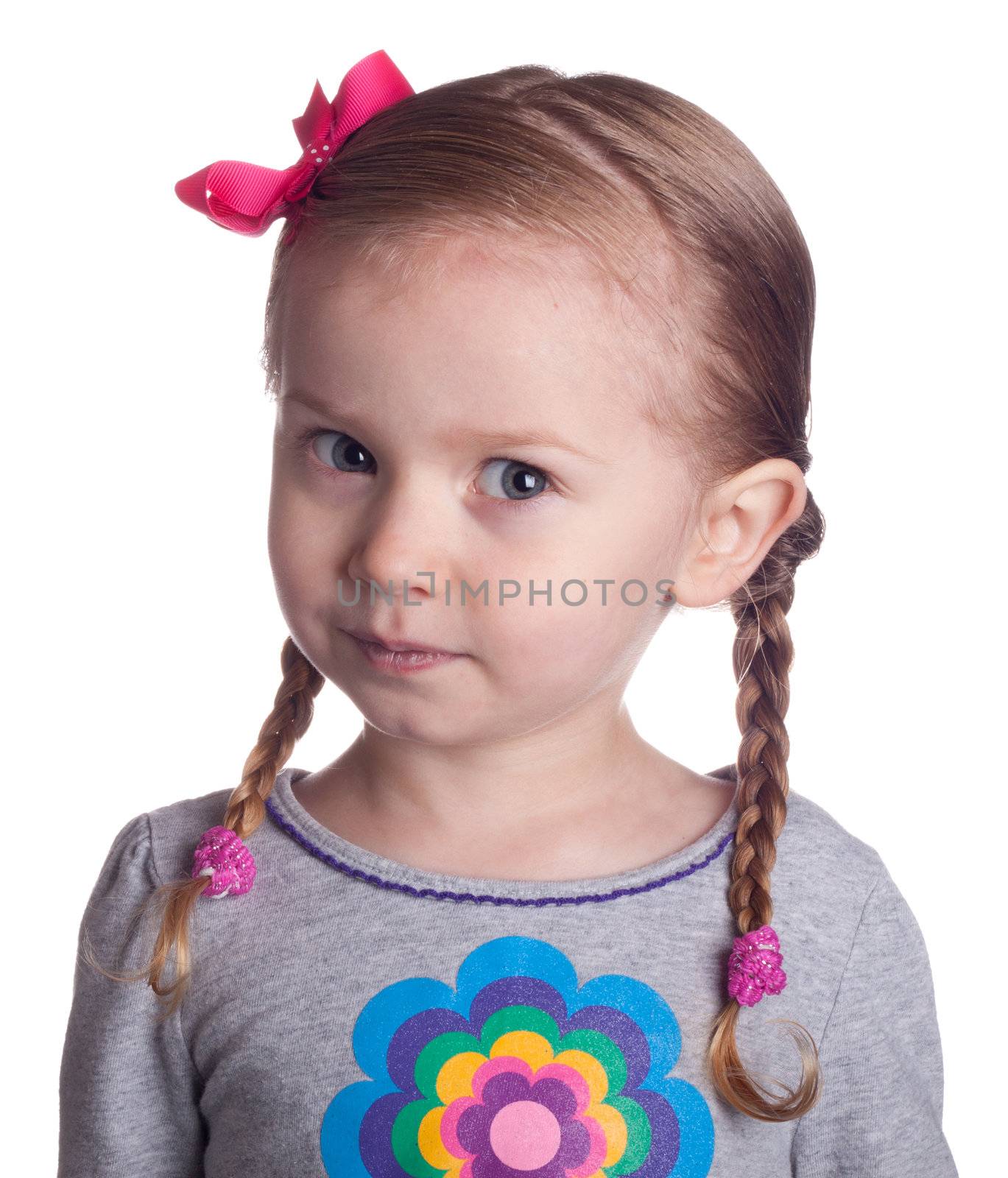 A look of surprise and slight anger towards the viewer.  An adorable little girl isolated on white.