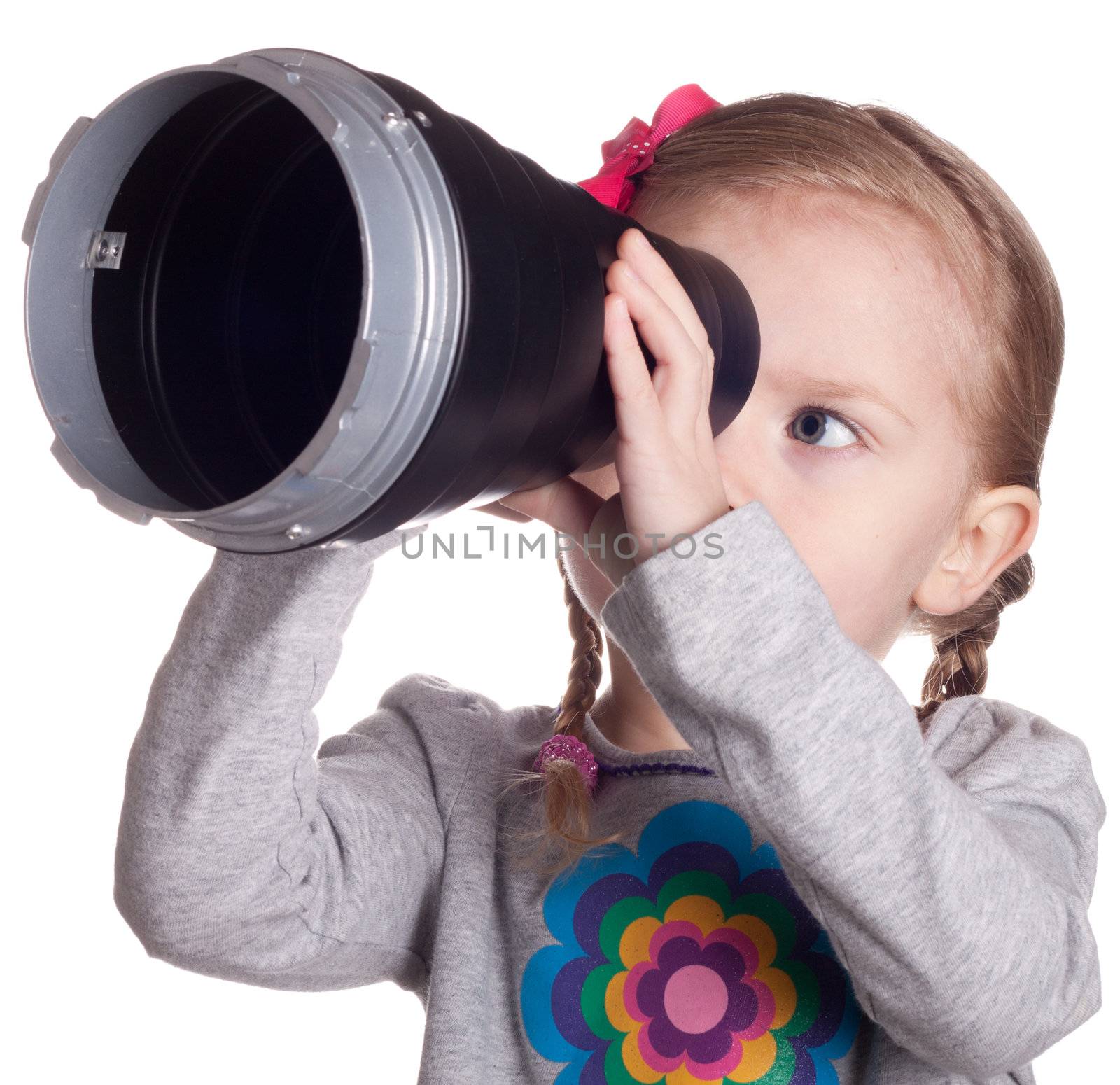 A girl looking through a metal cone.  She is make believing that it is a telescope.