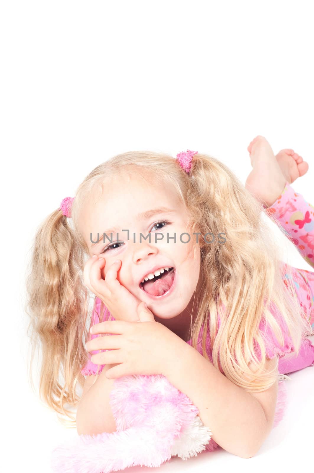 Little cute girl in pink and with ponytails in studio