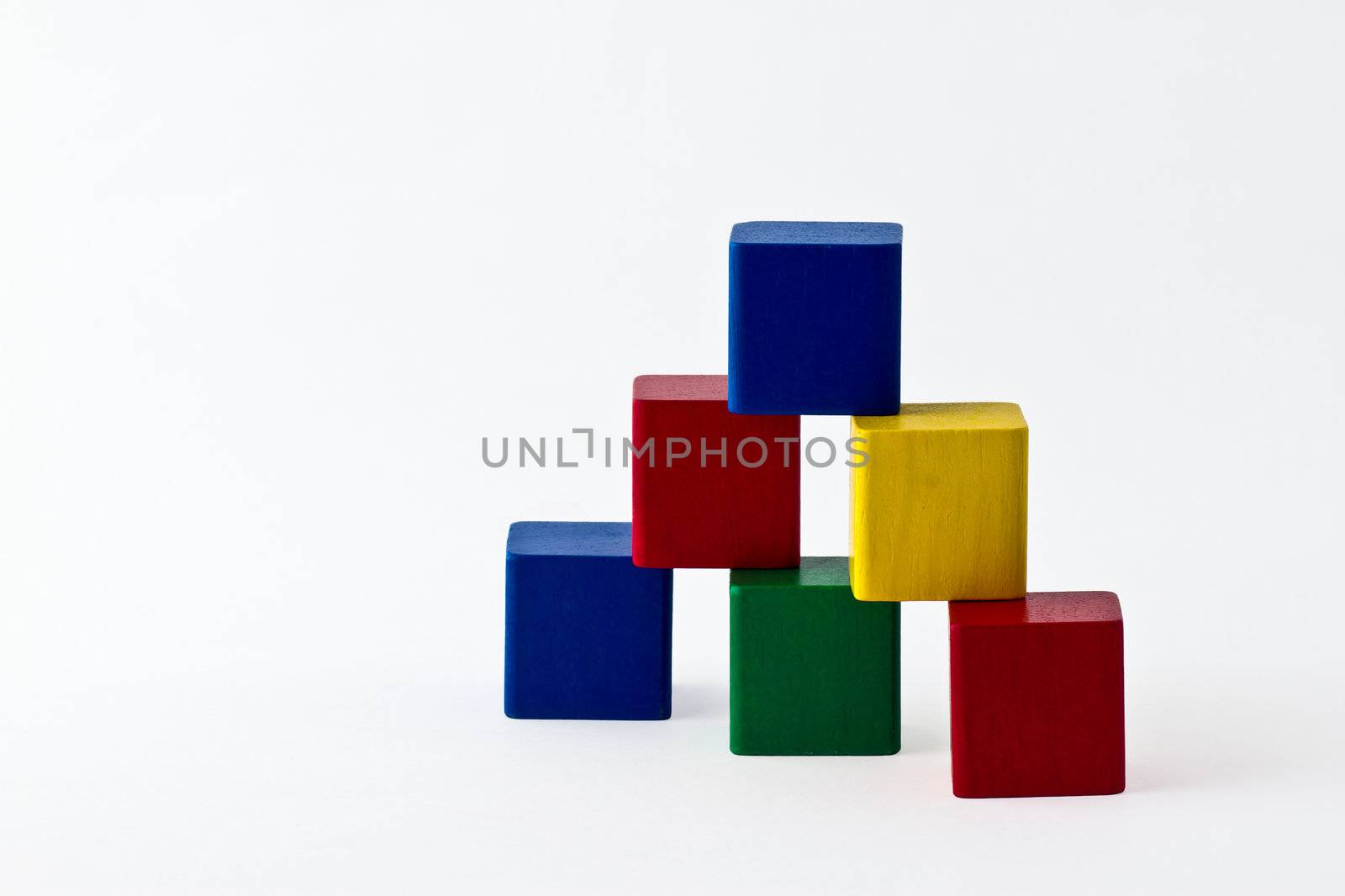 colorful wood building blocks stacked as pyramid. Isolated on white