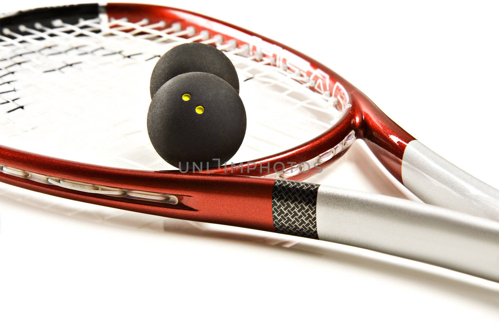 Close up of a red and silver squash racket and ball on a white background with space for text