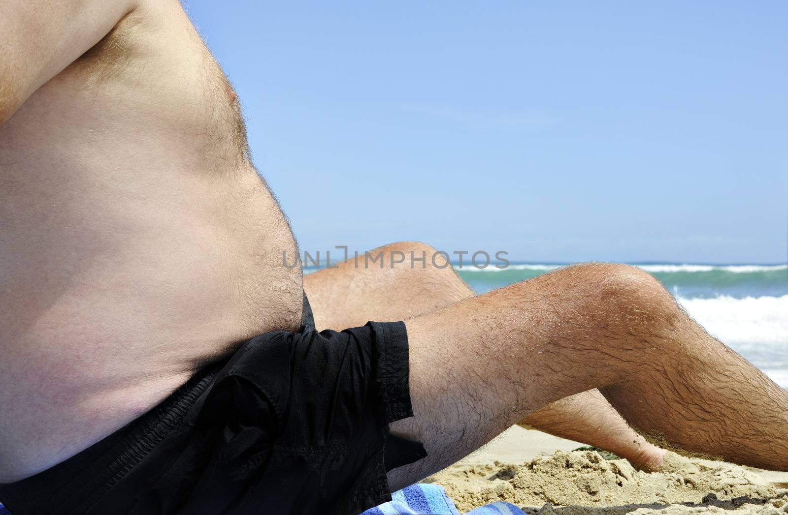 Unhealthy fat man sitting on the beach by tish1