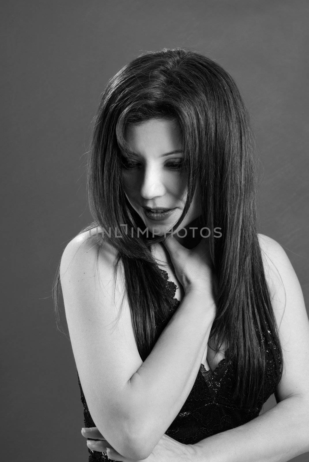 Beautiful demure adult woman with long brown hair gazing down