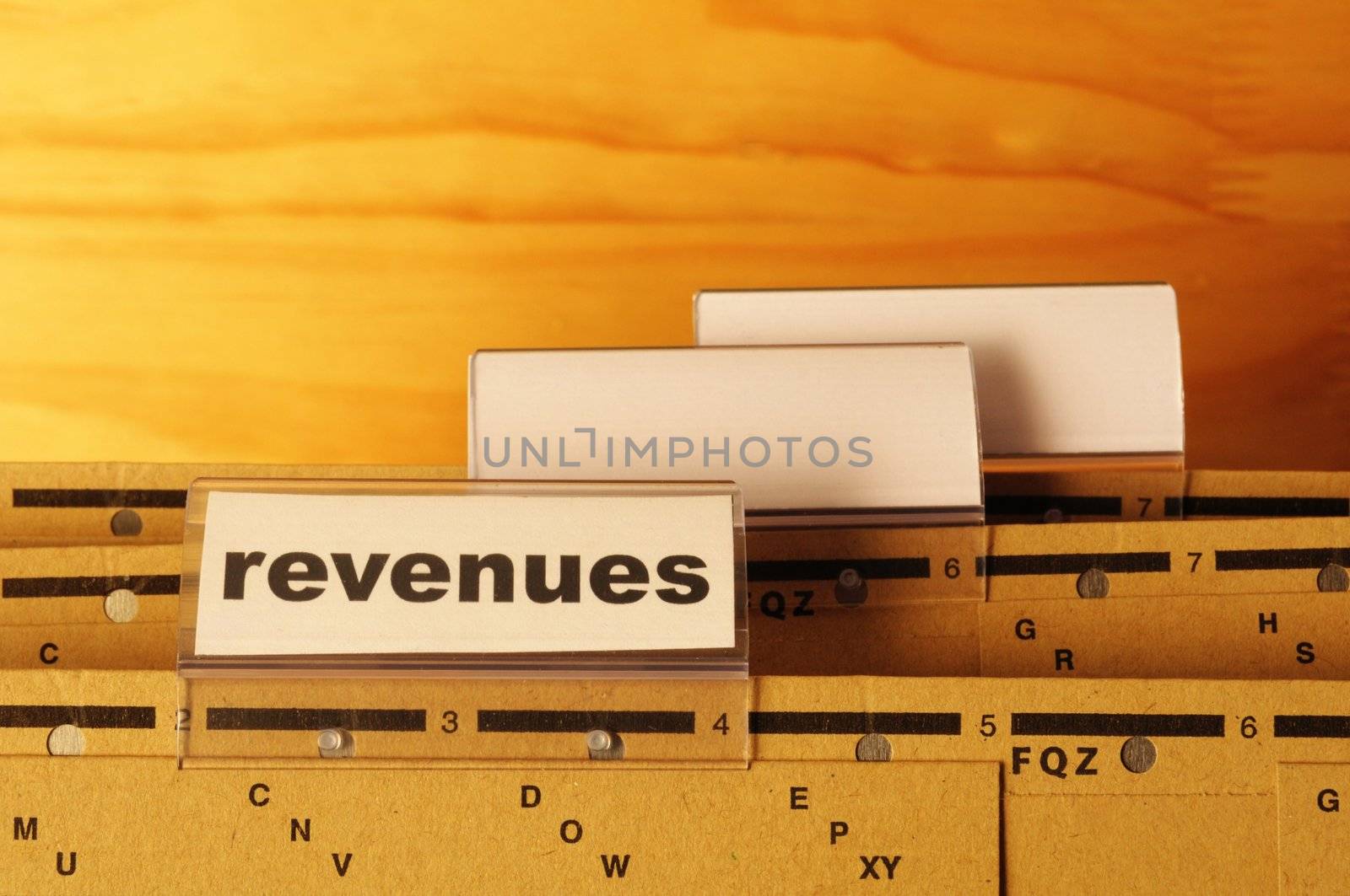 revenue or revenues word on business office folder showing financial success