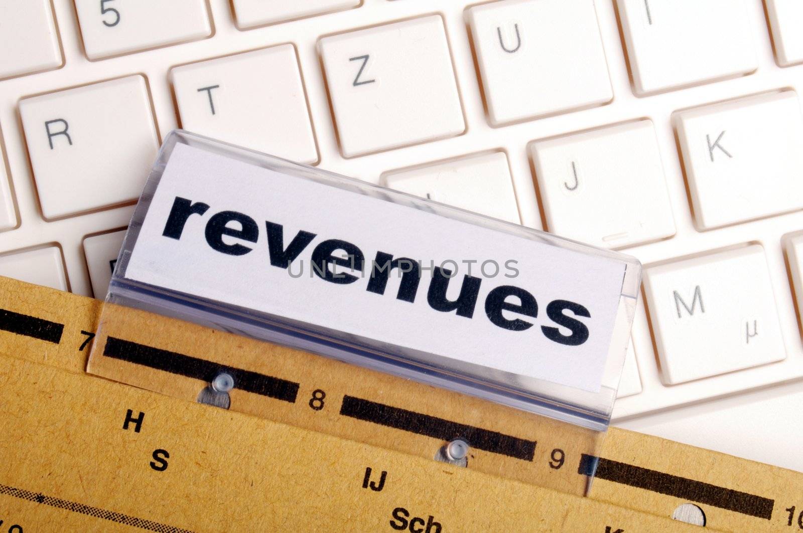 revenue or revenues word on business office folder showing financial success