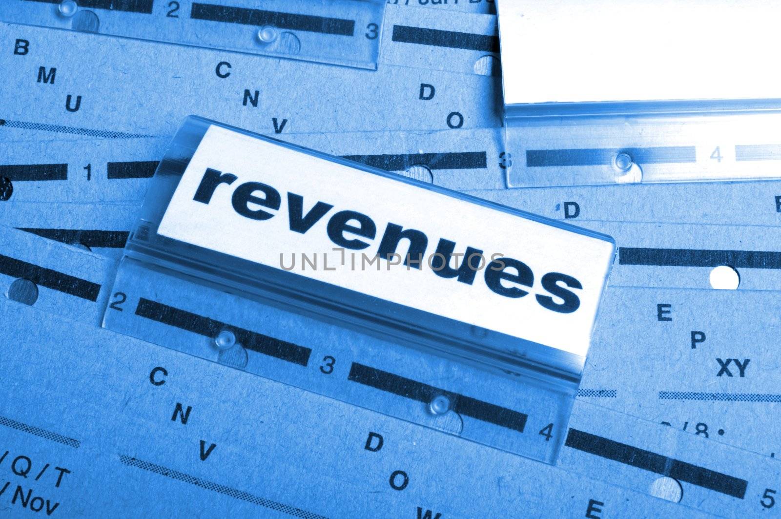 revenue or revenues word on business office folder showing financial success