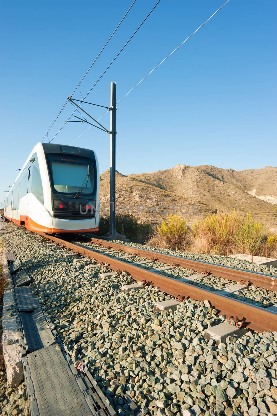 A modern electric train approaching the camera viewpoint