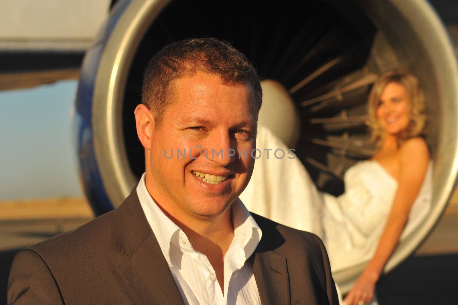 young wedding couple standing at intake of Boeing engine by Ansunette