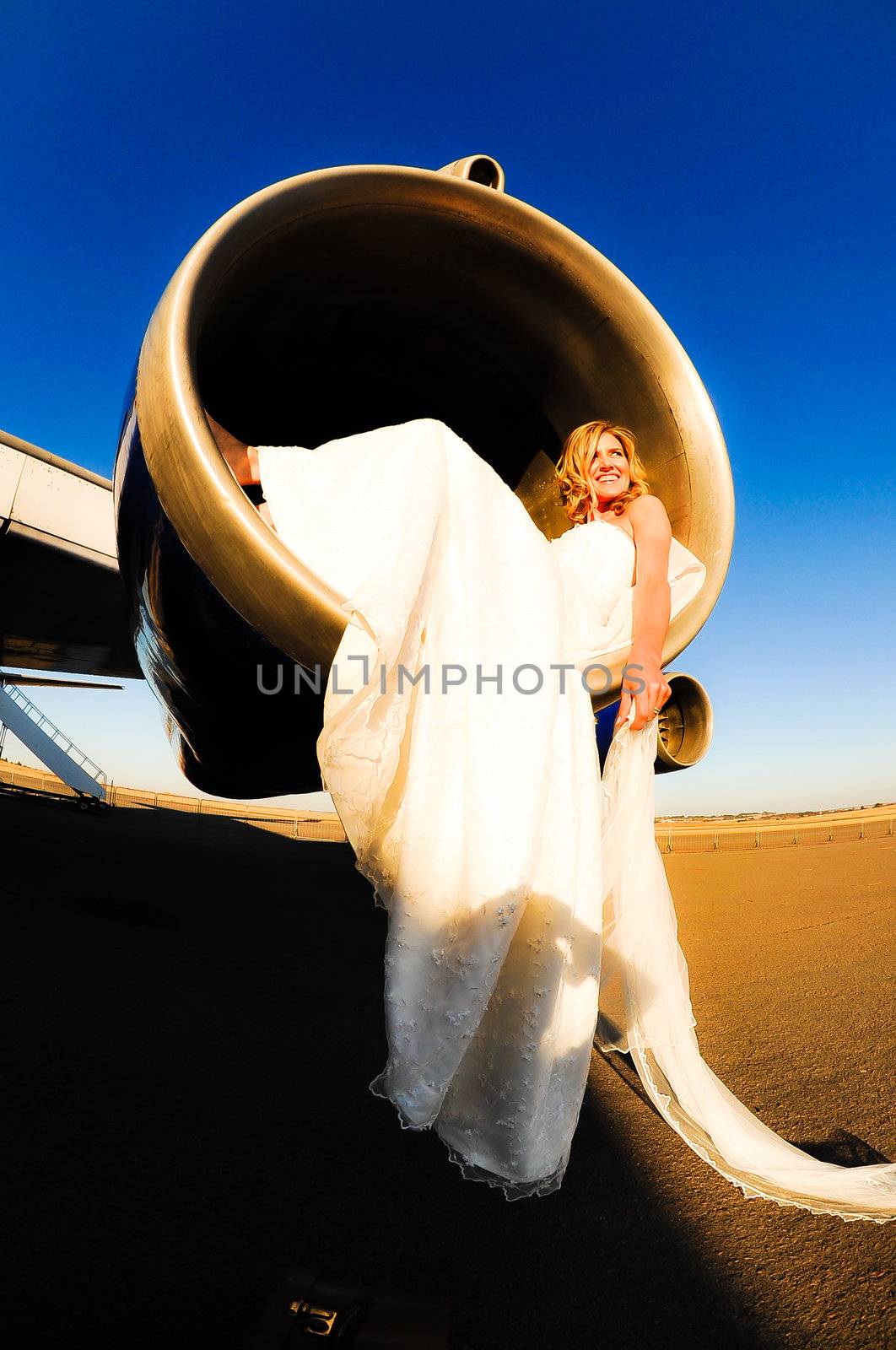 sexy young adult wedding model laying inside the engine intake of Boeing passenger aircraft