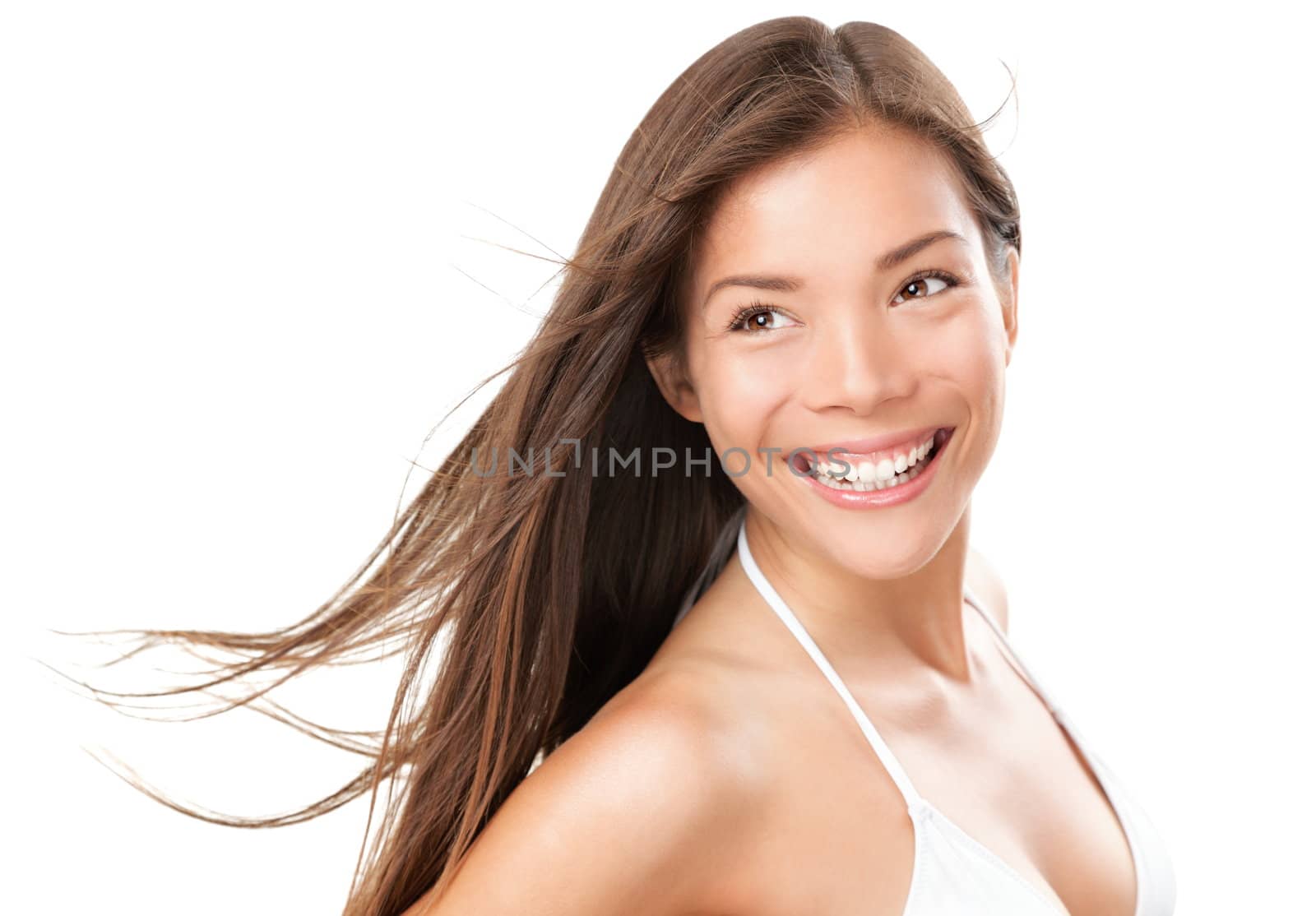 Beautiful bikini woman smiling isolated. Portrait of summer girl in white bikini with wind in the hair. Mixed Race Asian Caucasian model isolated on white background.