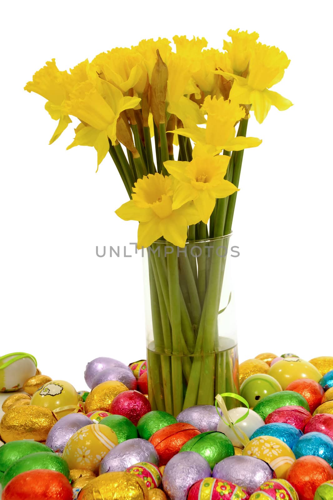 Daffodils in vase with many easter eggs taken on a clean white background.