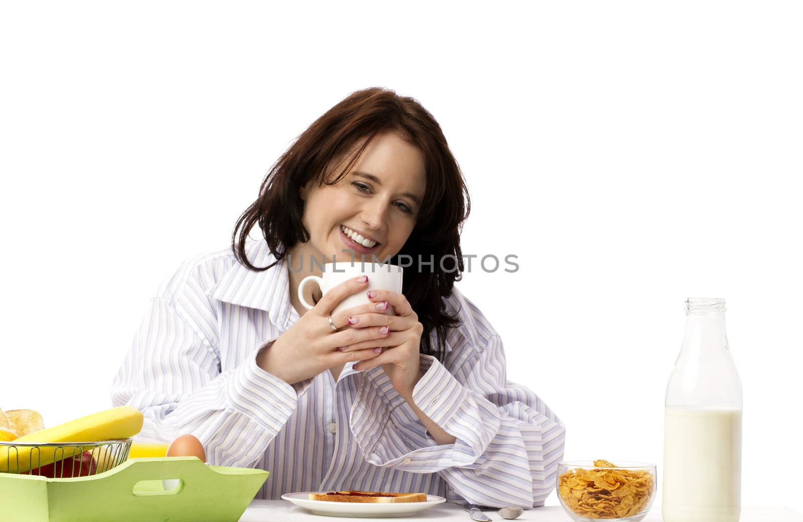 young laughing woman holding coffee mug at breakfast