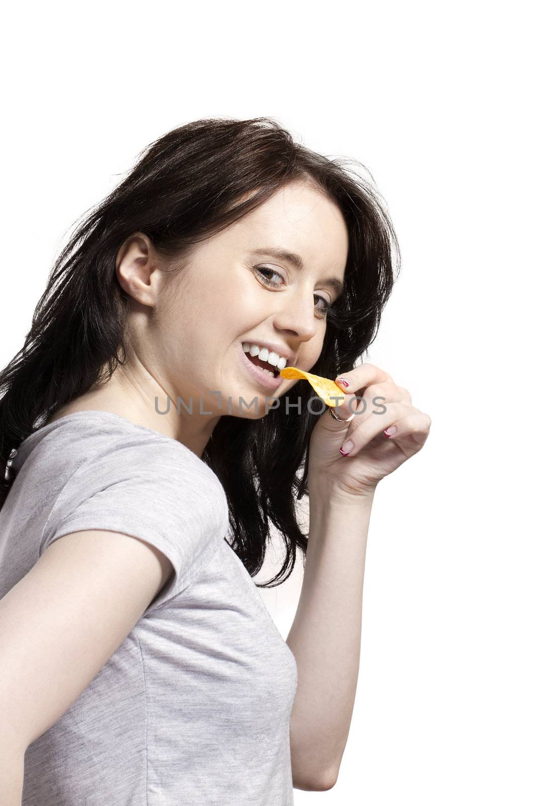 young woman from side eating potato chip with a smile