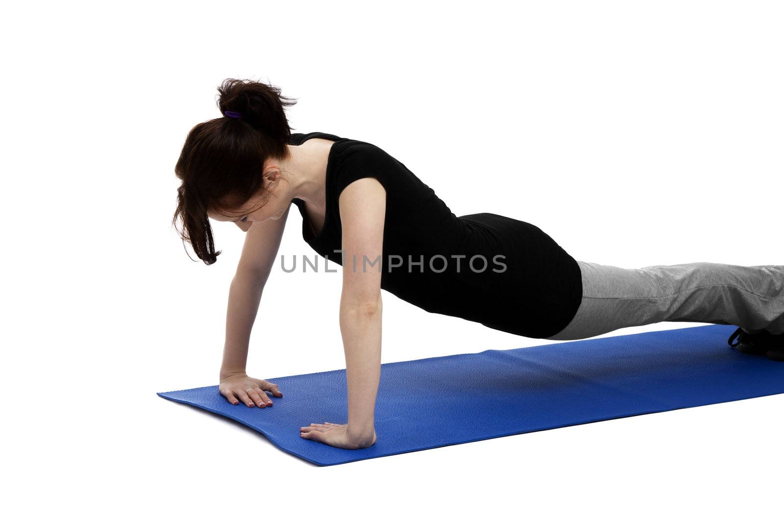 young woman exercising press ups on blue mat