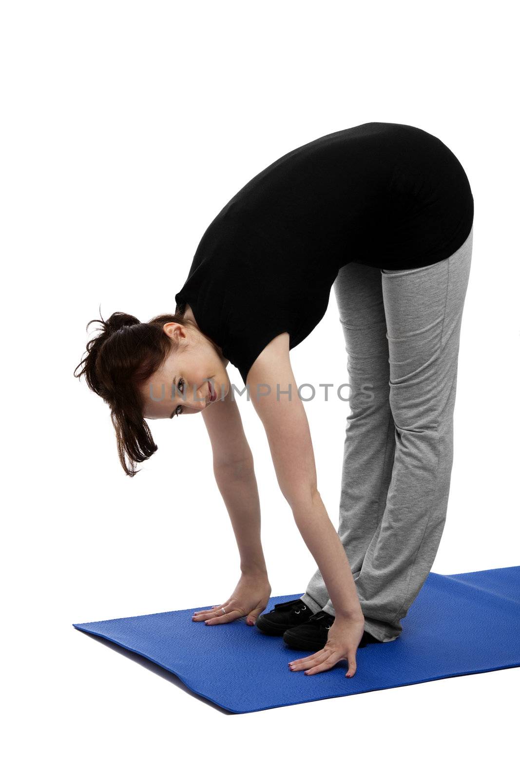 young woman exercising yoga placing hands on floor