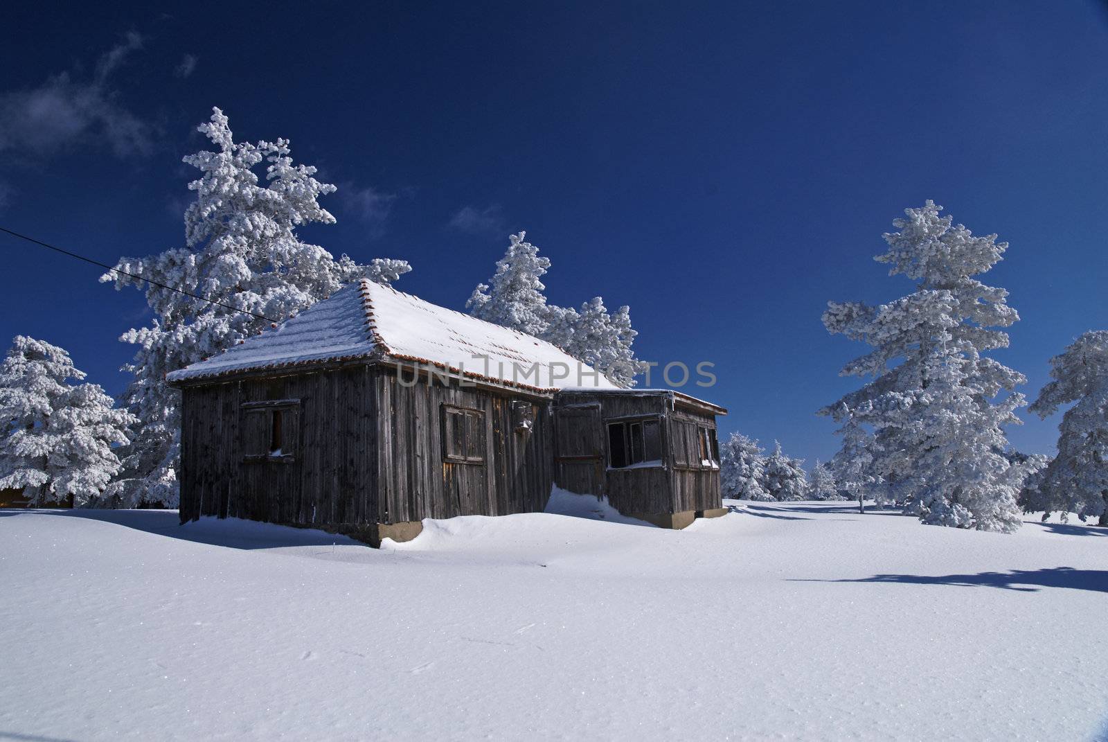 Mountain house in snow, winter sunny day