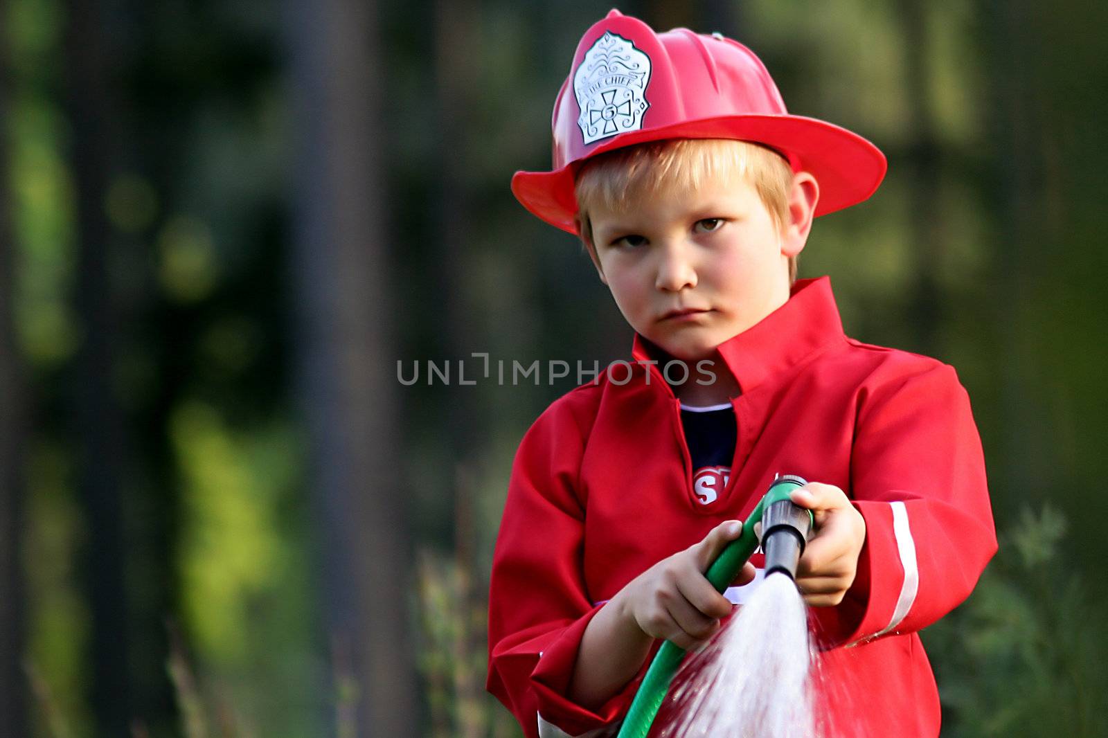 little fire man in the garden with the water hose