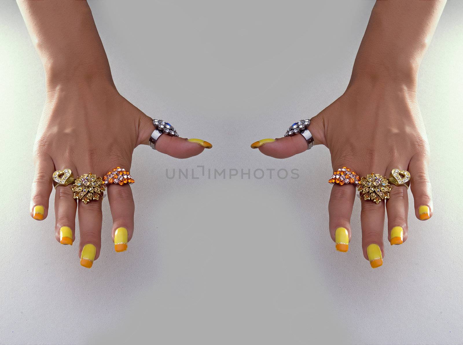 Hand showing big rings on fingers, colored nails